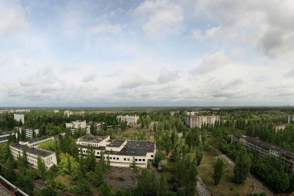 Pripyat les toits des maisons, le ciel enfumé et les couronnes des arbres