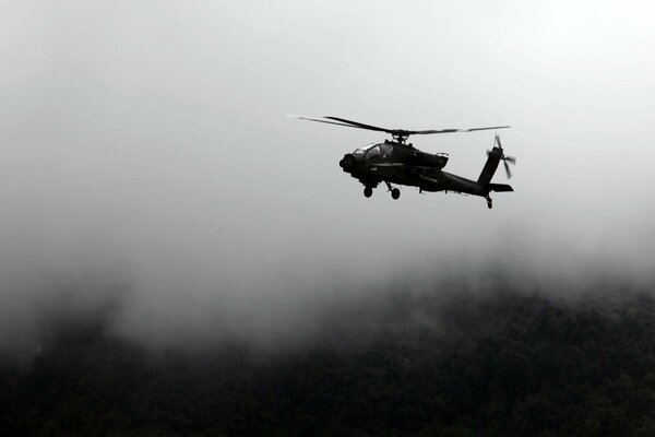 Helicóptero vuela sobre el abismo en la niebla