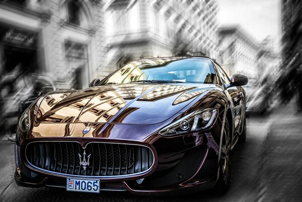 Cherry-colored maserati on a blurry background