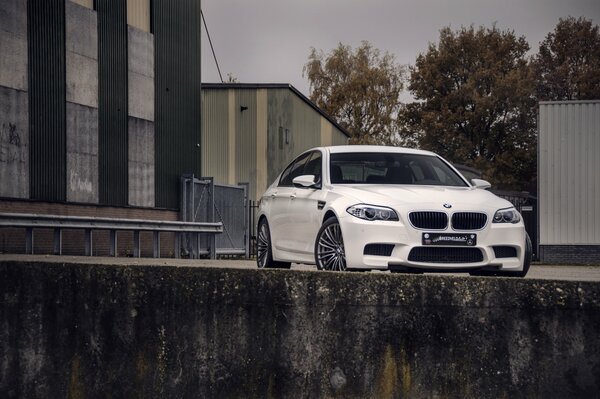 White BMW on a background of gray buildings