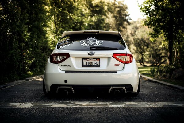 Coche blanco Subaru Impreza en el camino