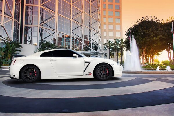 Nissan blanco en el fondo de un edificio alto