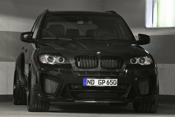 Black BMW on a gray wall background