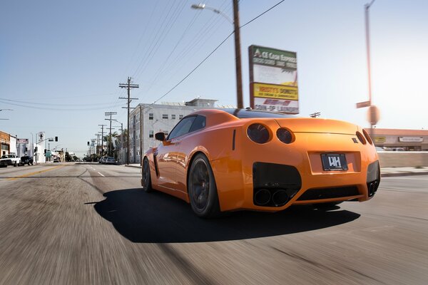 Pomarańczowy Nissan R35 na drodze z dużą prędkością