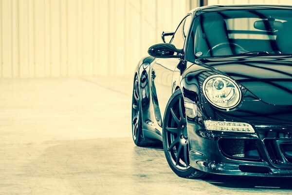 Shiny black Porsche on a bright , light background 