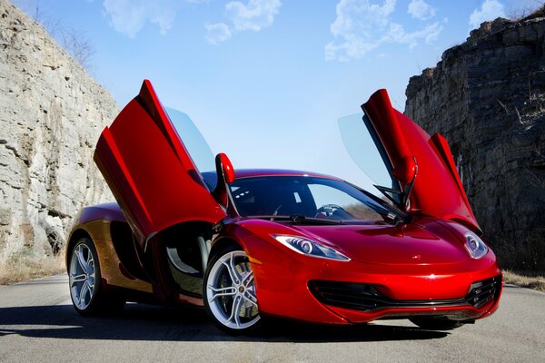 Roter McLaren zwischen den Felsen am blauen Himmelshintergrund