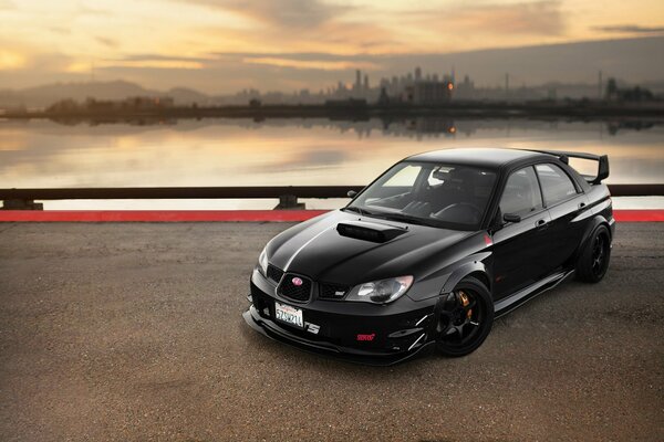 Black subaru impreza on a city background