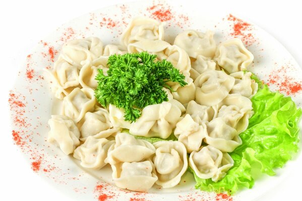 Dumplings and greens on a white plate