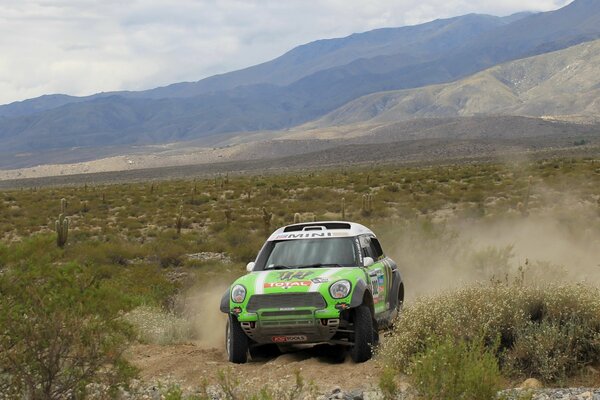 Mini cooper in sports Dakar on the background of mountains