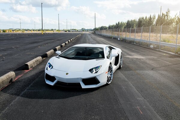 Vista frontal de un Lamborghini Aventador parado en una carretera vacía