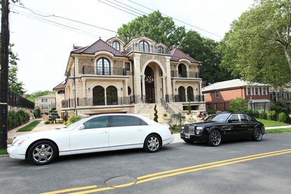 White may ah in front of a small mansion