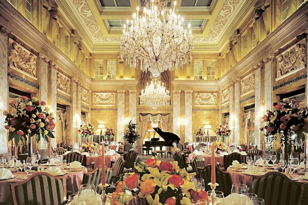 Photo of a salon with a large chandelier and a piano