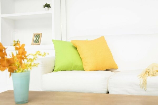 White sofa with pillows and flowers