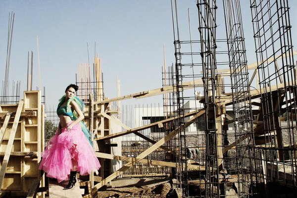 Chica en traje brillante en el sitio de construcción