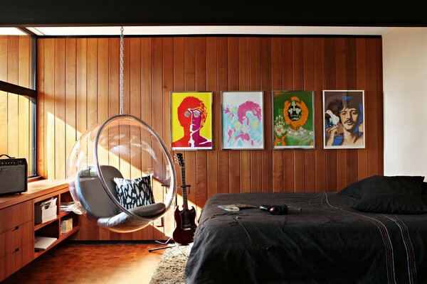 Retratos de los Beatles y una silla colgante en el interior del dormitorio