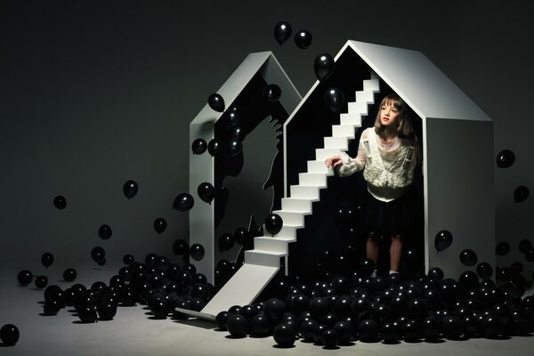 Fille dans la maison avec des boules noires