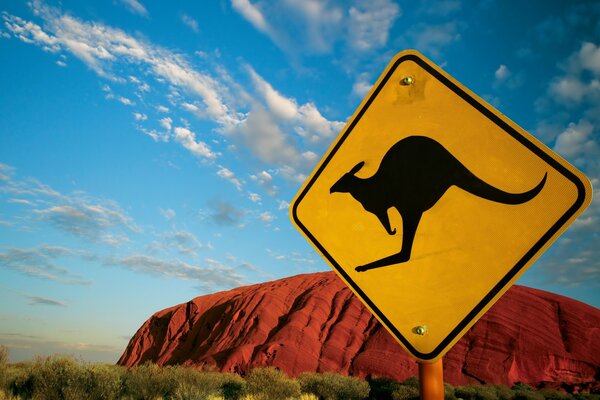 A sign warning about kangaroos on the background of red mountain