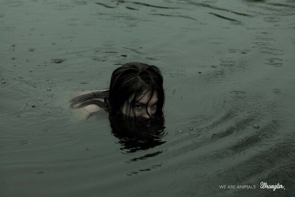 Chica en la lluvia sale del agua