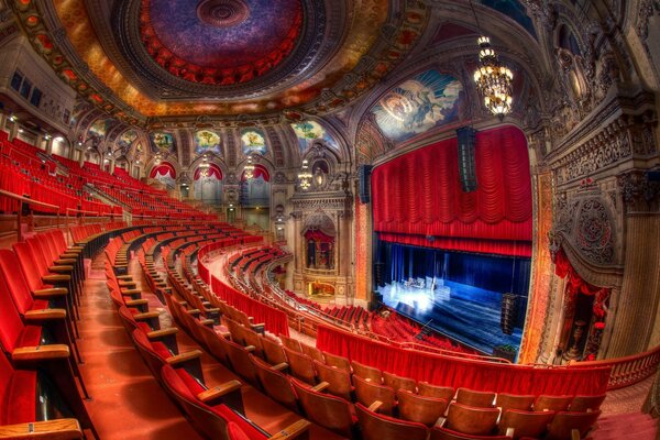 A deserted hall of a luxurious theater in Chicago with an empty stage flooded with light