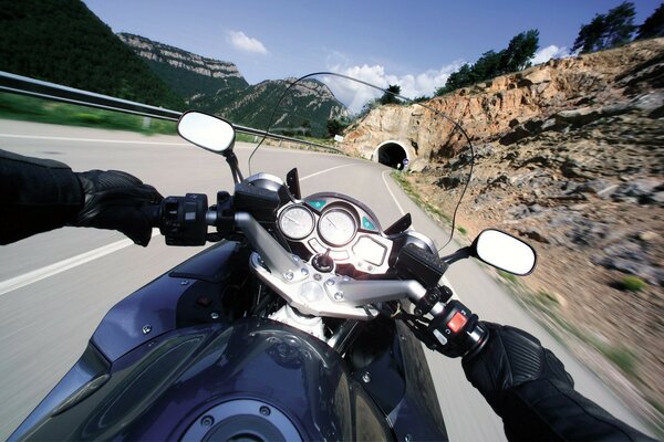 A motorcyclist rides at speed into a tunnel