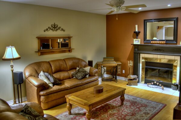 Leather sofa and armchair in front of the fireplace and the mirror hanging above it