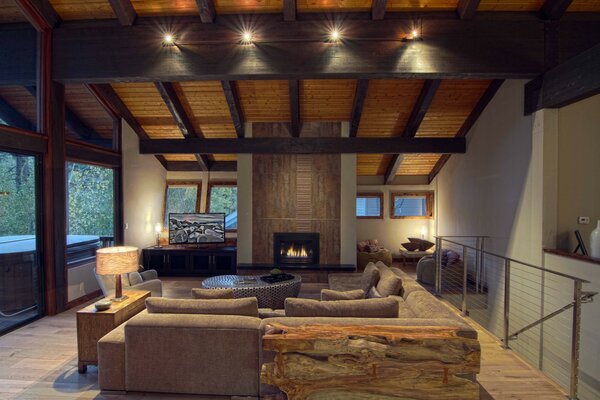 A lighted room in a designer house with a fireplace and stairs down