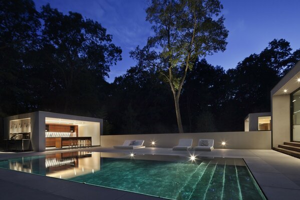 Kitchen and sun beds by the pool at night