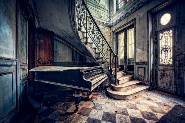 Un piano bajo las escaleras en una casa antigua