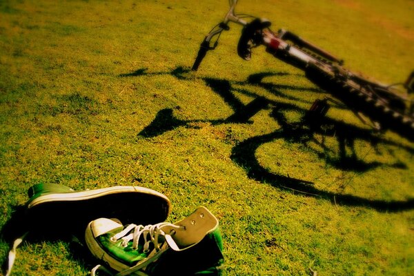 Vélo et baskets sur l herbe de jour