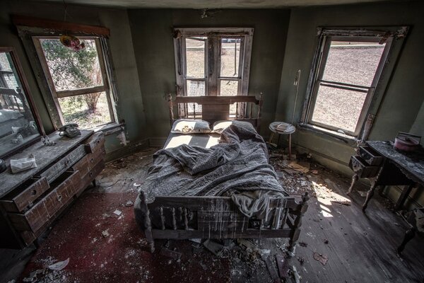 Chambre abandonnée avec lit et autres meubles