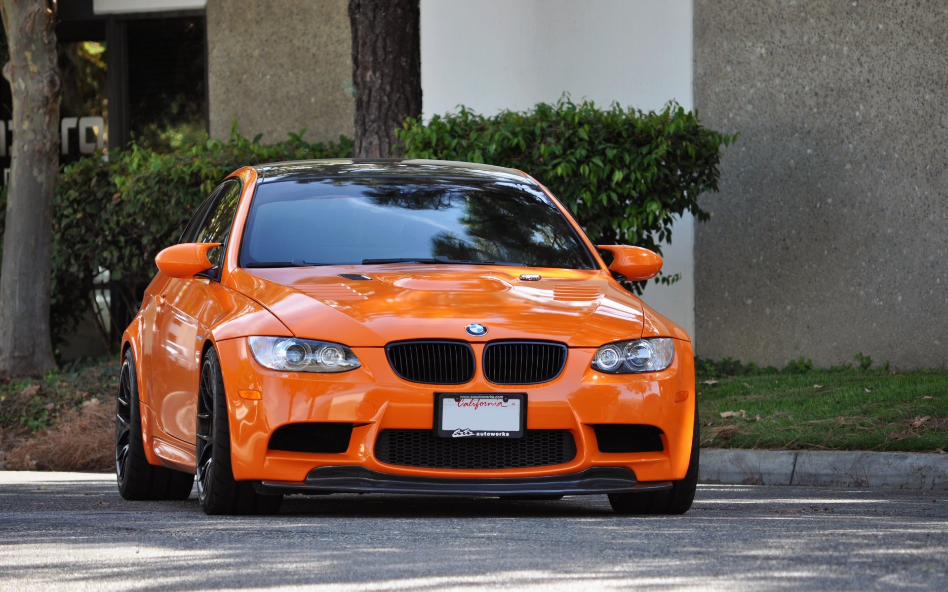 bmw m3 e92 orange.bmw pomarańczowy przód ulica droga poręcz krzewy drzewa