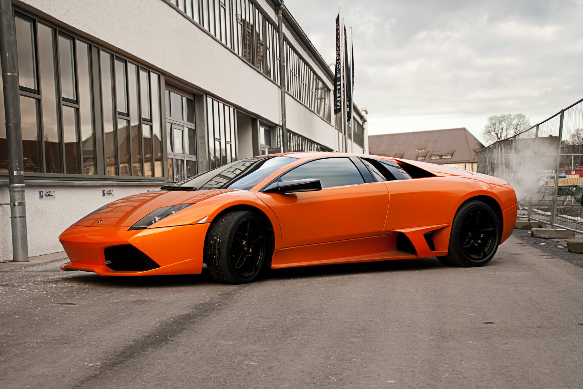 lamborghini murcielago orange lp640 lamborghini murcielago vue latérale disques noirs bâtiment fenêtre clôture ciel nuages