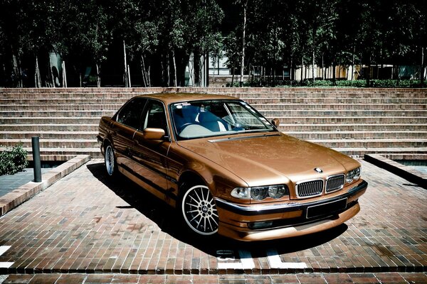 Bmw 740 E38 dorado en el parque de la ciudad