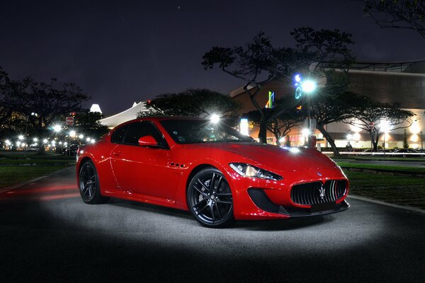 Maserati rojo en la calle a la luz de la noche