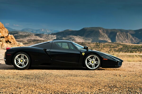 Schwarzer Ferrari enzo in den Bergen an einem sonnigen Tag