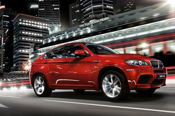 BMW X6 rouge sur fond de maisons d habitation