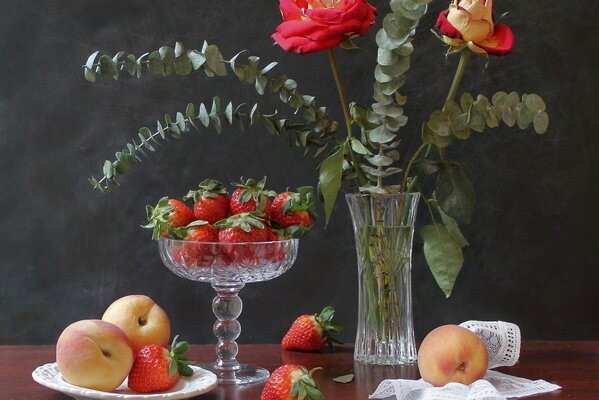 Belle nature morte de fraises. pêches et fleurs