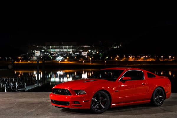 Red Ford Mustang and the lights of the night city