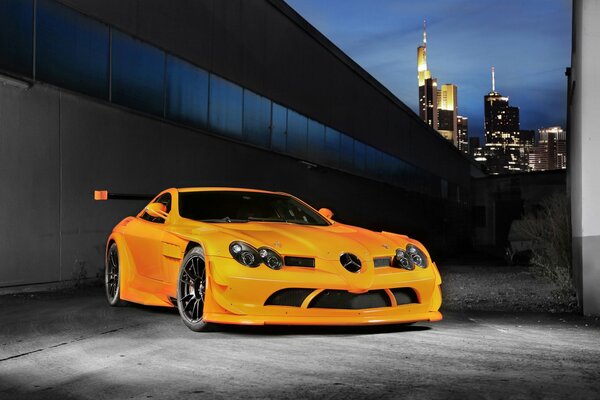 Orange Mercedes Benz on the background of skyscrapers