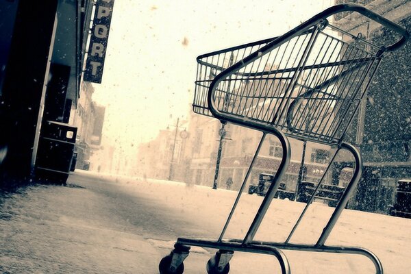 Image of a winter street with a purchased stroller on the background of a snowfall