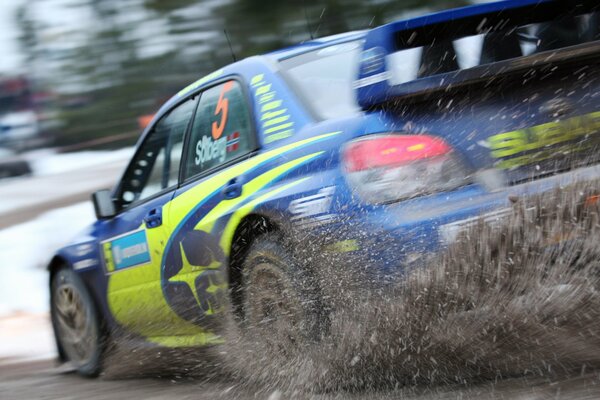 Subaru Impreza is racing on the highway, throwing dirt and-under the rear wheels