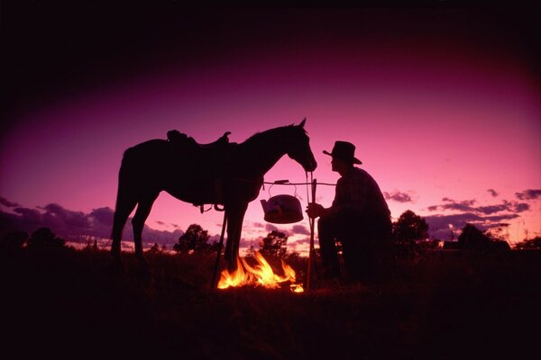 Cowboy und Pferd machten am Abend ein Lagerfeuer