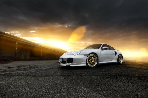 Silberner Porsche mit Highlights bei Sonnenuntergang