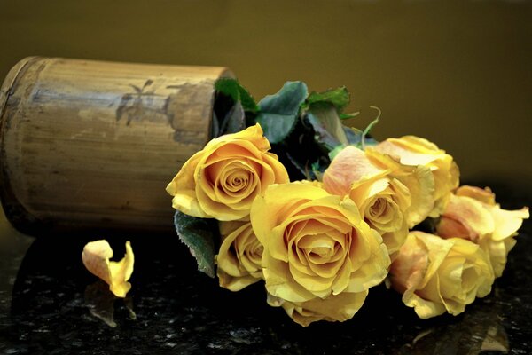 Bouquet of yellow roses in a fallen vase