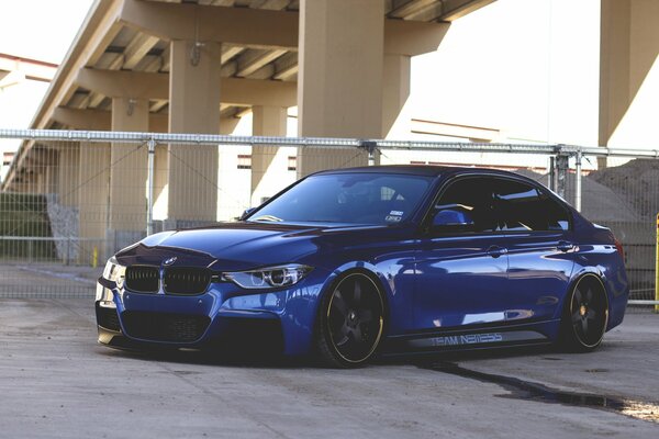 Blue BMW in the city under the overpass