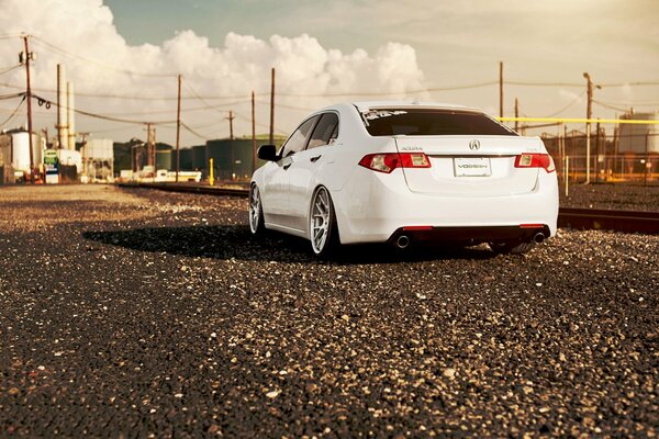 On the gravel near the rail of the railway on the gravel is an acura