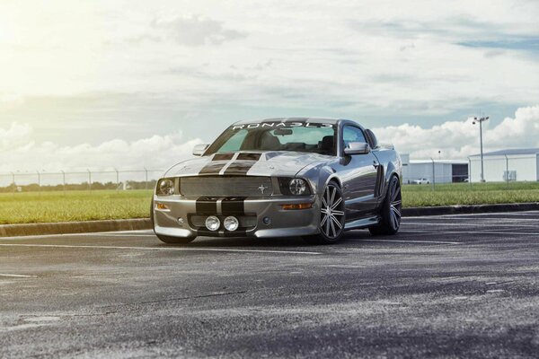 Une Ford Mustang argentée roule sur la route