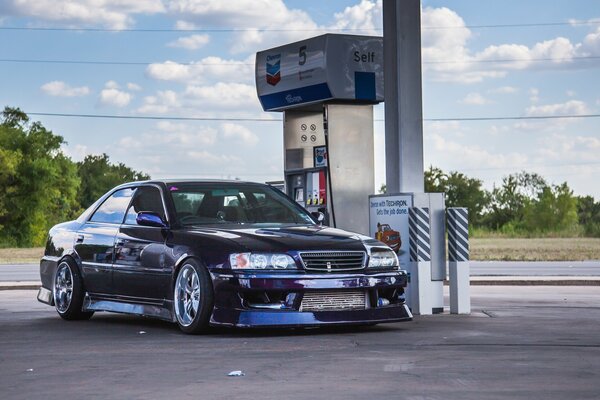 A tuned American car at a gas station