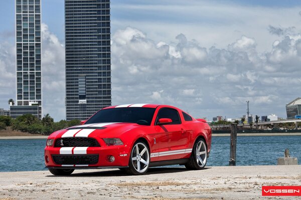 Red car on the background of the sea and clouds