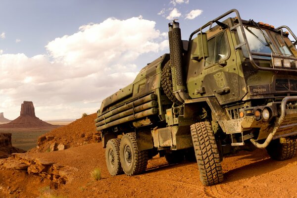 The truck is standing among the hills in the desert